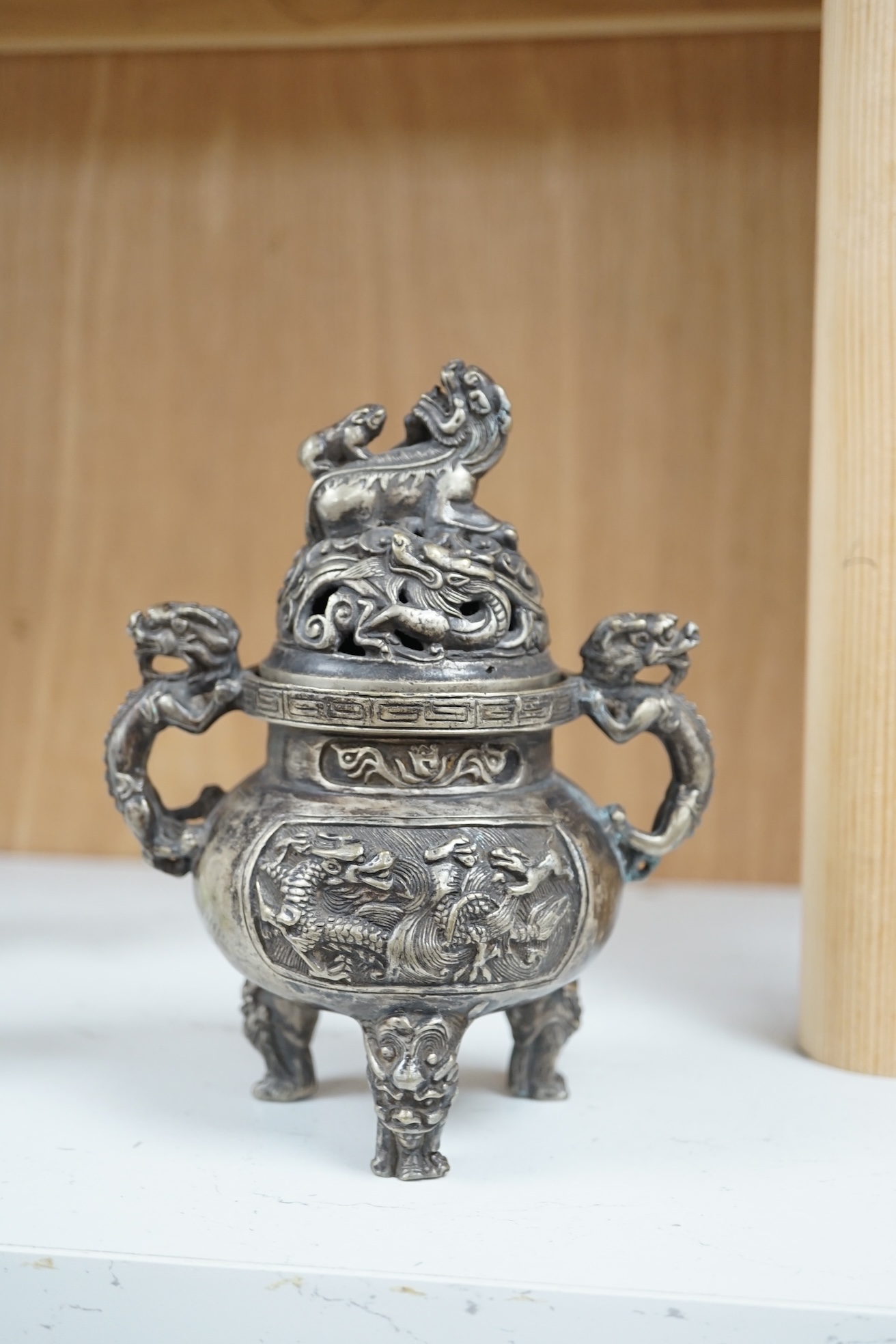 A Chinese silvered bronze lidded ‘dragon’ censer, 16cm tall. Condition - fair to good